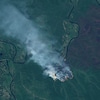Image satellite montrant une colonne de fumée blanche sur un sol vert. 