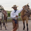 Filipe Masetti Leite à côté de ses deux chevaux habillé en cowboy.