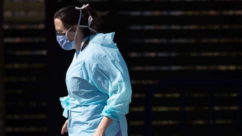 A hospital worker wearing a face shield and mask is seen at a COVID-19 assessment centre for staff at Lions Gate Hospital, in North Vancouver, on Thursday, March 19, 2020. THE CANADIAN PRESS/Darryl Dyck 
