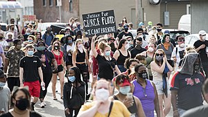 Protesters marching in Minneapolis on May 26, 2020, the day after Floyd's death. A protester's sign reads, "Justice for George Floyd" and "#I CANT BREATHE".
