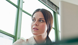 Young office worker looking out of window
