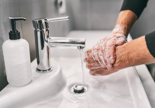 A person thoroughly washing their hands with soap