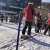 Des personnes en ski attendent leur tour en bas d'un remonte-pente.