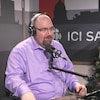 Un invité devant un sapin de Noël dans un studio de radio 