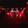 Une salle de spectacle vide, éclairée par des spots rouges au plafond.