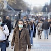 Un homme et une femme portant des masques marchent dans la rue.