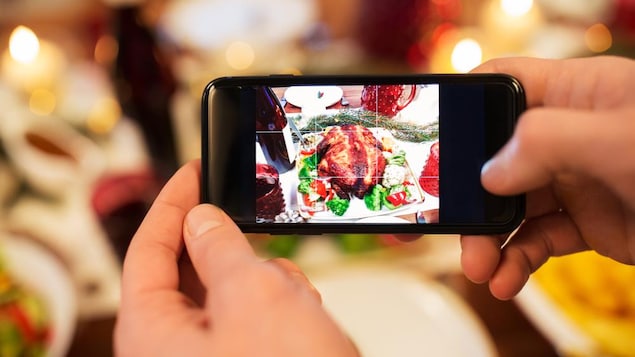 Un festin de Noël vu à travers un écran de cellulaire.