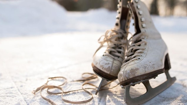 Photo d'une vielle paire de patins à glace sur une patinoire extérieure.