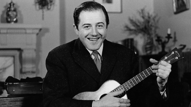 Le chanteur Raymond Lévesque, une guitare à la main, dans le salon de sa résidence.