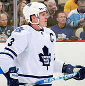 Dion Phaneuf holding his ice hockey stick with both hands, while playing with the Maple Leafs.