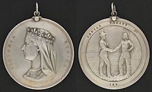 Photograph showing the two sides of a round silver medal, showing the profile of Queen Victoria on one side and the inscription "Victoria Regina", with the other side having a depiction of a man in European garb shaking hands with an Aboriginal in historic first nation clothing with the inscription "Indian Treaty 187"