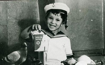 A child holds up a KKL-JNF blue box to collect donations in this undated photo. The blue box was one of the first ways to raise money for the fledgling KKL-JNF Jewish National Fund and was common in many Jewish homes. (Courtesy KKL-JNF)