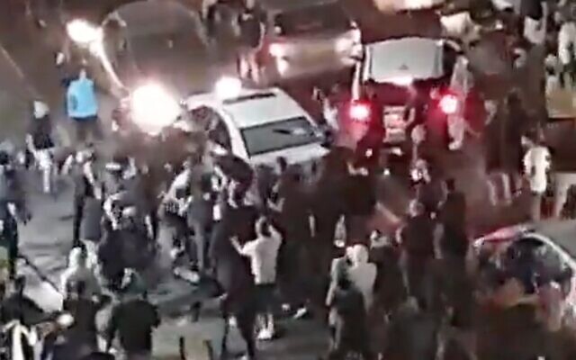 Screen capture from video of a crowd of Jewish protetors pulling an Arab man from his vehicle in Bet Yam, May 21, 2021. (Twitter)