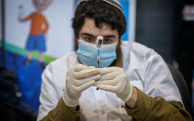A medical worker prepares a COVID-19 vaccine injection, at a Clalit vaccination center in Jerusalem, on March 8, 2021. (Yonatan Sindel/Flash90)