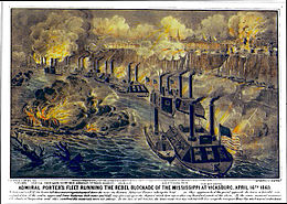 A line of about a dozen Union gunboats on the Mississippi River exchange fire with the town above on a cliff