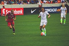 photo of Canadian midfielder Quinn (left) defending against American forward Alex Morgan during the 2016 CONCACAF Women's Olympic Qualifying Championship Final, 21 February 2016
