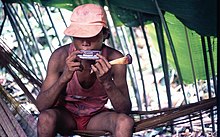 A Nukak Makú young man playing the Harmonica and holding an animal bone flute like instrument.jpg