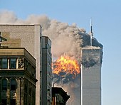 The twin towers are seen spewing black smoke and flames, particularly from the left of the two.