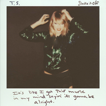 A Polaroid picture of Taylor Swift in a bob haircut and leather jacket. She seems to be dancing in an elated mood. The lyric "It's like I got this music in my mind saying it's gonna be alright" is written in black marker in the footer. On the upper left is Swift's initials "T.S.", and the upper right is the title "Shake It Off".