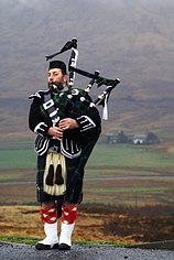 Man playing bagpipes in the Highlands