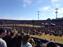 large crowd of people in an outdoor sports stadium on a clear day