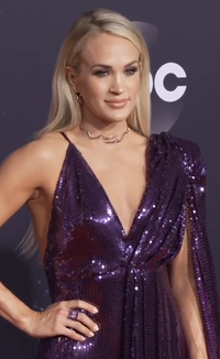 A bust shot of singer Carrie Underwood in a purple dress.