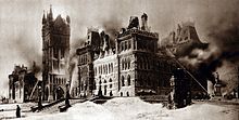 The Parliament of Canada the morning after the fire of 1916, with firemen spraying water on the building