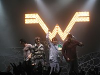 Four men together at the front of a stage
