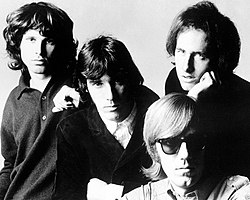 The Doors in 1967: Jim Morrison (left), John Densmore (center), Robby Krieger (right) and Ray Manzarek (seated)