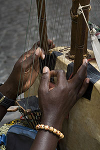 Playing position of a kora, showing how the strings are notched into both sides of the square bridge