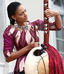 Sona Jobarteh tuning a 22-string kora with open machine head tuners, 2017.