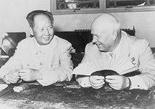 Photographie de deux hommes souriant assis à une table